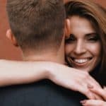 smiling woman hugs man